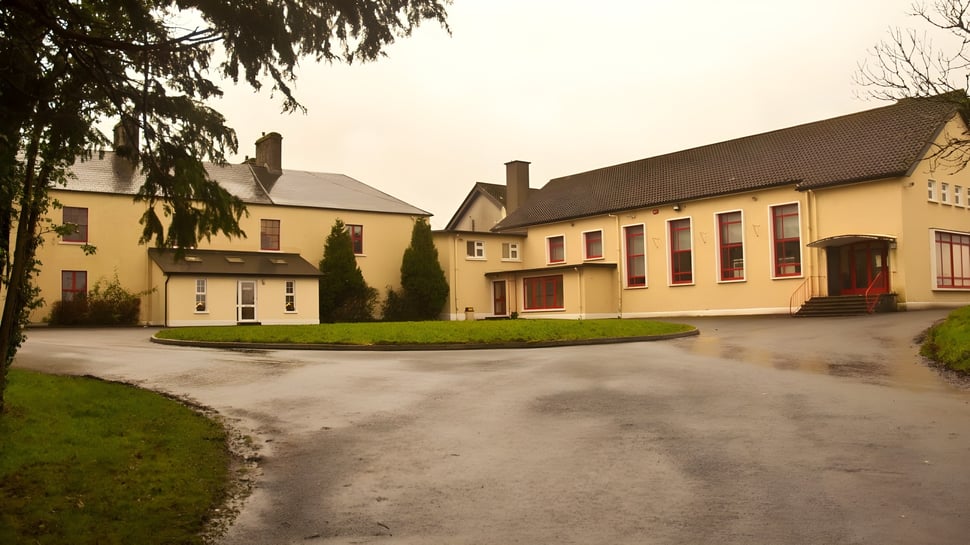 Eine Dorfansicht mit gelben Gebäuden und einem Kiesweg auf dem Gelände der Balla Secondary School.