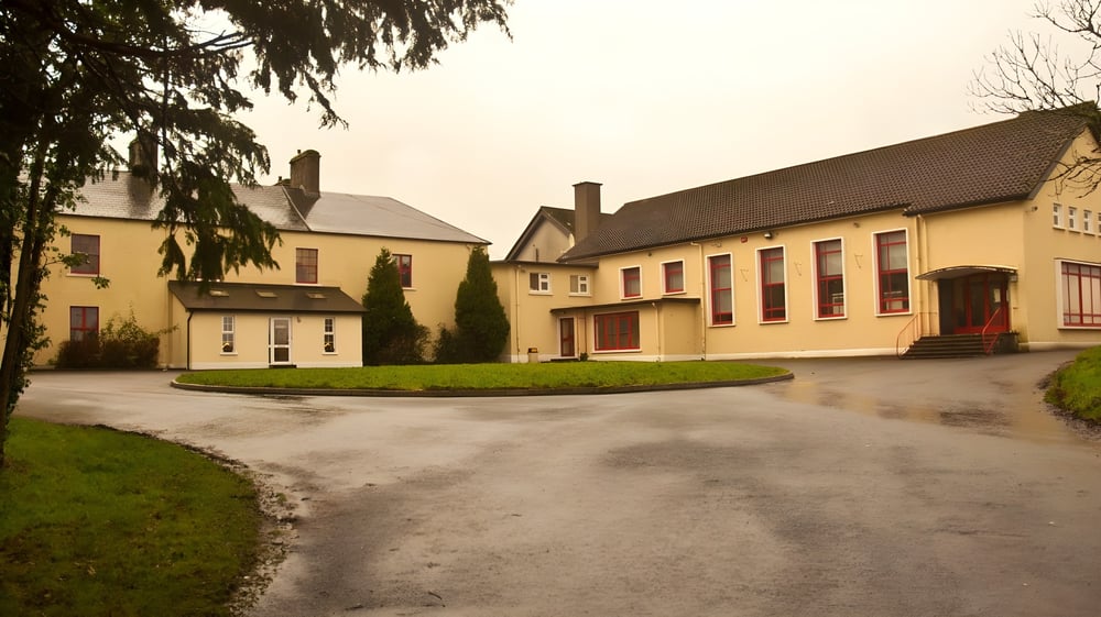 Eine Dorfansicht mit gelben Gebäuden und einem Kiesweg auf dem Gelände der Balla Secondary School.