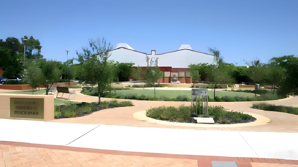 Der Außenbereich des Ballajura Community College zeigt einen zentralen Brunnen mit umgebender grüner Anlage und einem markanten Gebäude im Hintergrund.