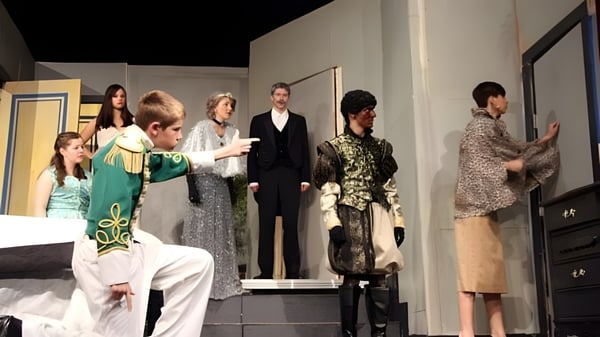 Eine Gruppe von Schülerinnen und Schülern der Ballard High School steht in verschiedenen formellen und traditionellen Kleidern im Flur.