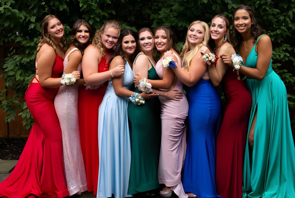 Eine Gruppe junger Schülerinnen der Ballingarry Presentation School steht im Freien auf einer grünen Wiese in bunten formellen Kleidern.