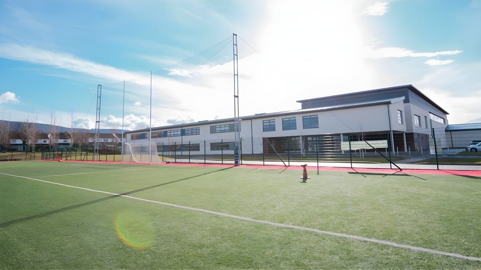 Moderne Sportanlage mit Tennisplatz vor dem mehrstöckigen Gebäude auf dem Gelände der Ballinteer Community School.