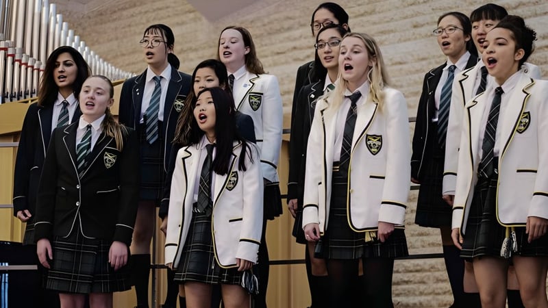Schüler der Balmoral Hall High School stehen in der Aula und singen gemeinsam als Chor.