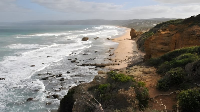 Eine felsige Küstenlandschaft mit einem Pfad zum Strand ist in der Umgebung der Balmoral State High School zu sehen.