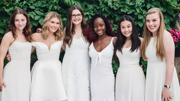 Sechs Schülerinnen der Balmoral Hall High School stehen vor einer grünen Pflanzenwand.