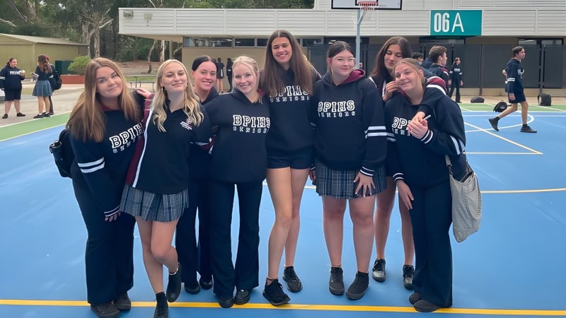 Eine Gruppe Schülerinnen steht gemeinsam auf dem Basketballplatz der Banksia Park International High School im Freien.