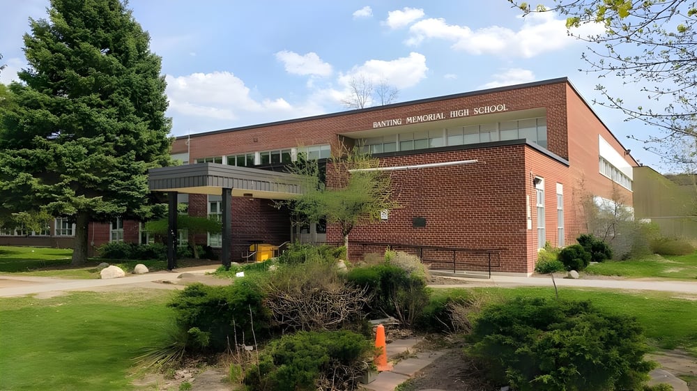 Das Backsteingebäude der Banting Memorial High School ist von Bäumen und Grünflächen umgeben.