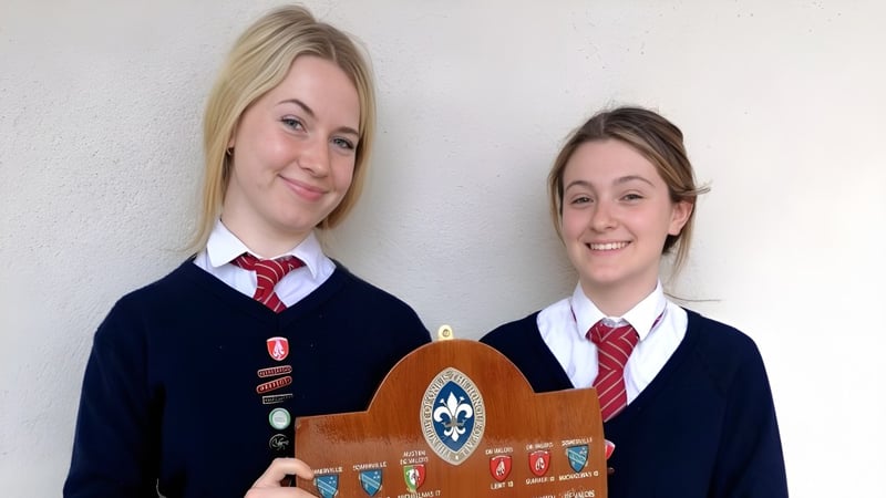 Zwei Schülerinnen stehen lächelnd vor einer weißen Wand am Bantry Community College.