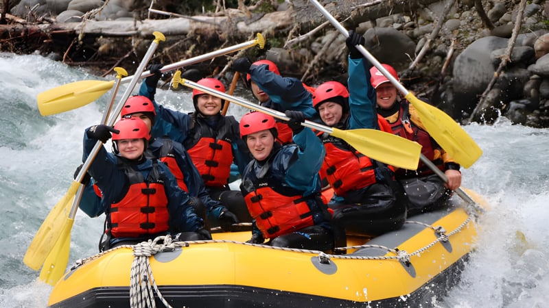 Schüler der Barnard Castle School beim Rafting auf einem Wildwasserfluss im felsigen Gelände.