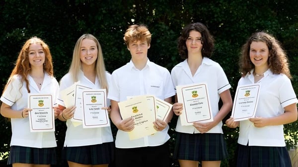 Fünf Schülerinnen und Schüler der Barrenjoey High School stehen mit Zertifikaten vor einem grünen Hintergrund.