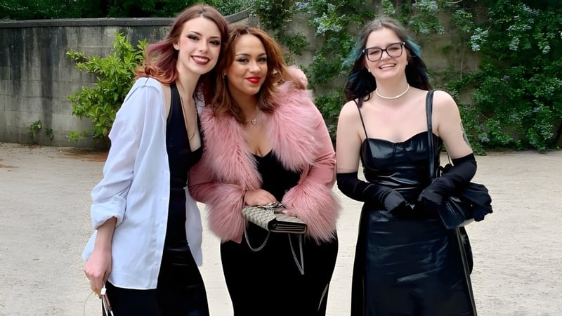 Drei Schülerinnen der Bath Academy posieren zusammen in einem grünen Außenbereich.