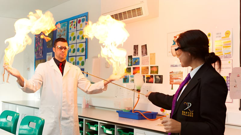 Zwei Personen führen im Labor des Baxter College ein Experiment mit sichtbar aufsteigendem Rauch durch.