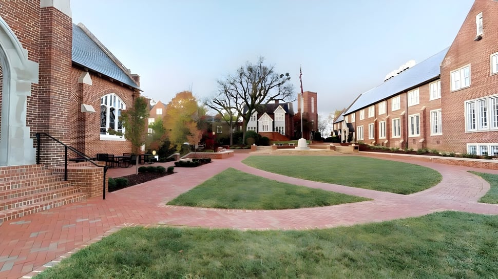 Ein ziegelgepflasterter Weg führt durch einen grünen Innenhof auf dem Campus der Baylor School.