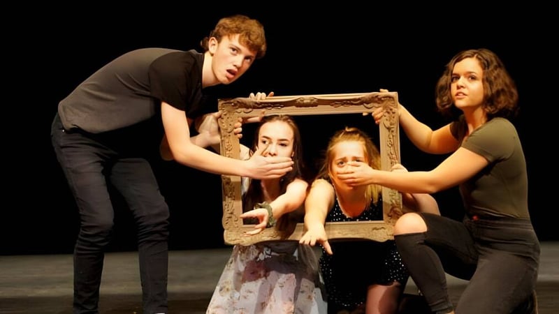 Vier Schülerinnen und Schüler der Bayridge Secondary School halten gemeinsam einen Holzrahmen vor dunklem Hintergrund.