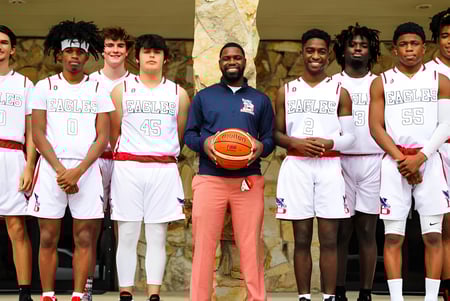 Schüler der Beacon of Hope Christian School tragen weiße Trikots und posieren gemeinsam in einer Sporthalle.