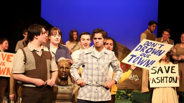 Schüler der École Secondaire Beaumont Composite High School halten Schilder und Banner bei einer Demonstration vor blauem Hintergrund.