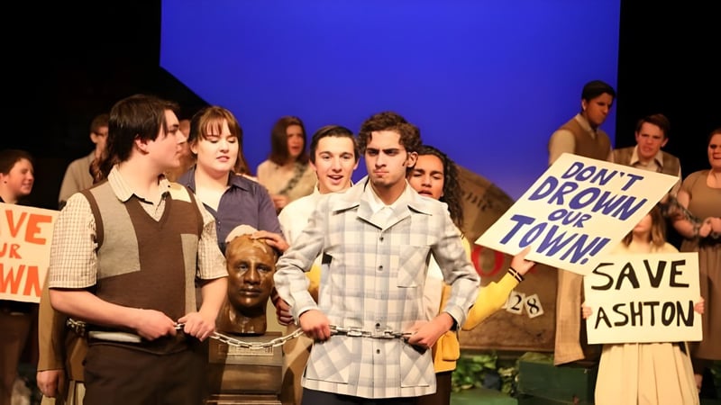 Schüler der École Secondaire Beaumont Composite High School halten Schilder und Banner bei einer Demonstration vor blauem Hintergrund.