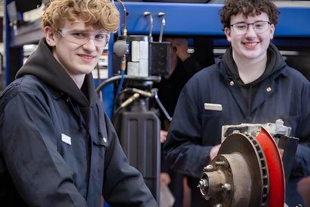 Zwei Schüler der École Secondaire Beaumont Composite High School stehen in der Werkstatt zwischen verschiedenen Werkzeugen.