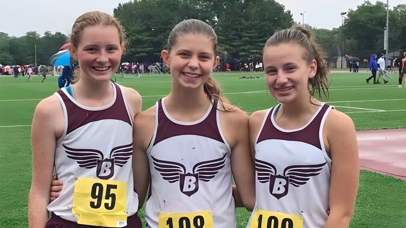 Drei Athletinnen der Beaver Area High School stehen gemeinsam auf einem Rasenfeld während eines sportlichen Wettbewerbs.