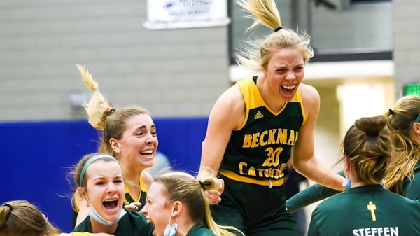 Eine Gruppe weiblicher Basketballspielerinnen der Beckman Catholic School feiert auf dem Spielfeld.