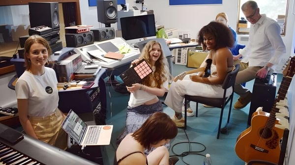 Eine Gruppe Schülerinnen und Schüler der Bedales School arbeitet gemeinsam in einem Musikstudio mit verschiedenen Instrumenten und Technik.