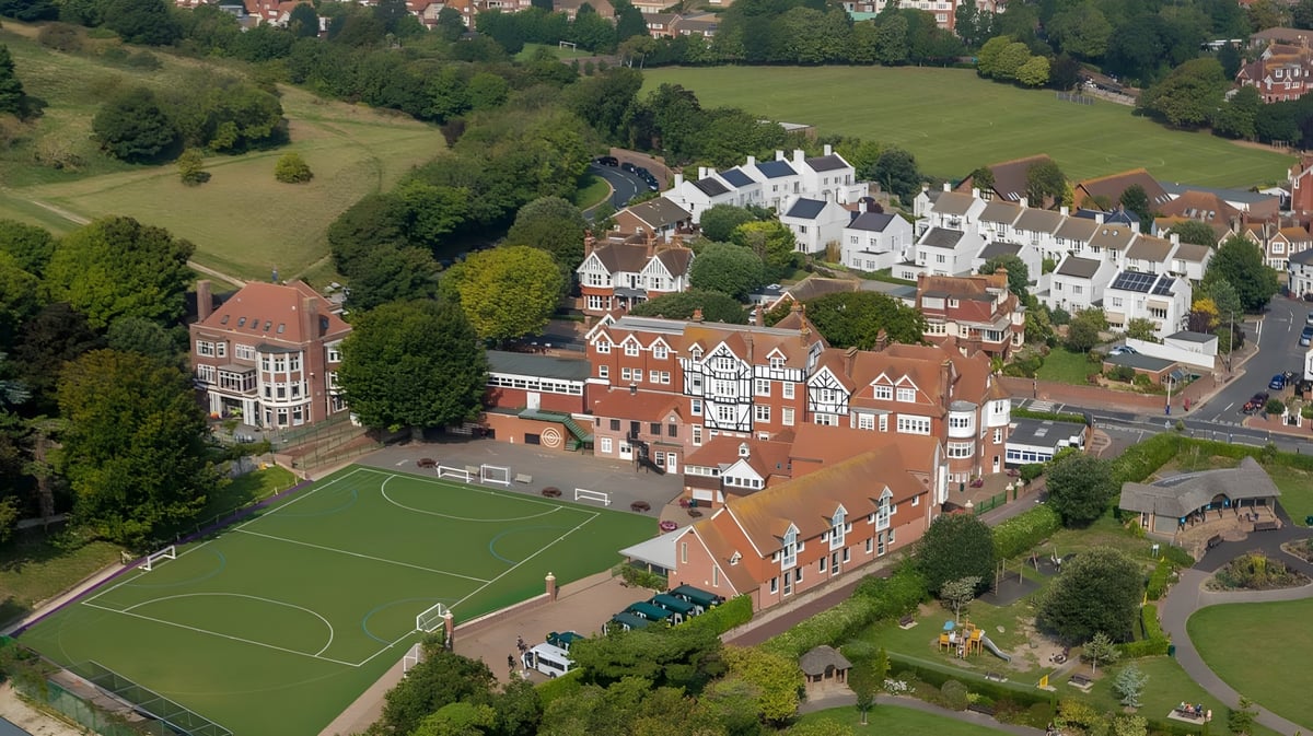 Luftbild des Dorfes mit traditionellen Tudor-Gebäuden und Fußballfeld nahe der Bede's Senior School.