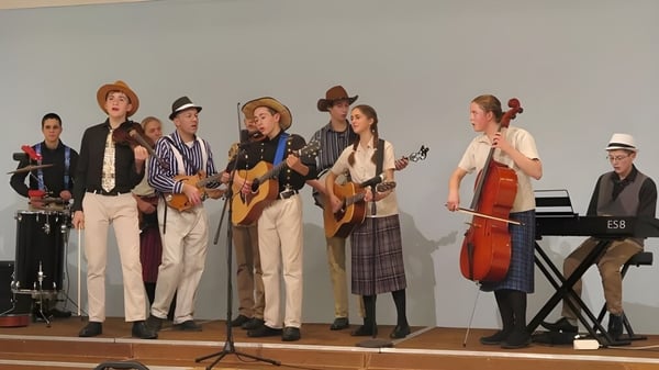 Musikergruppe der Beech Grove School tritt auf einer Bühne mit schlichter Kulisse auf.