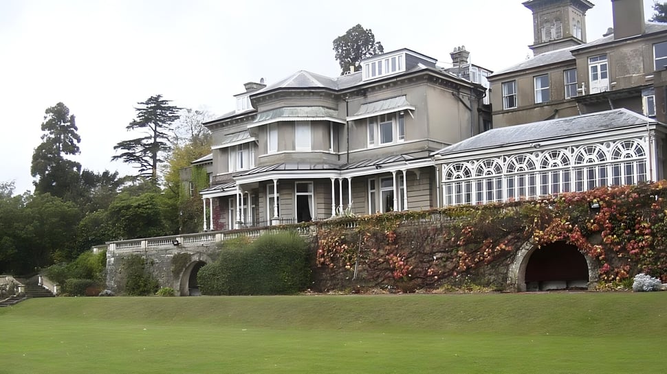 Die historische Villa auf dem Gelände der Beechwood Sacred Heart School ist von grünen Wiesen und einem schmiedeeisernen Zaun umgeben.