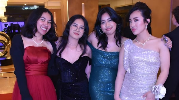 Vier Schülerinnen des Belmont City College posieren gemeinsam in einem Veranstaltungsraum.