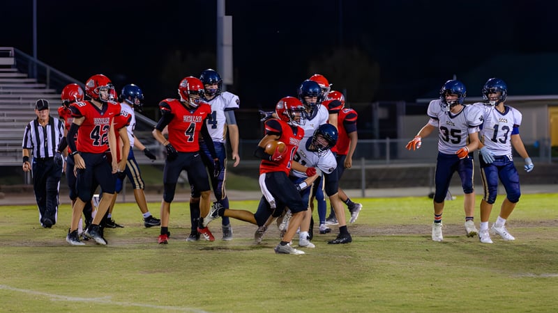 Spieler der Berean Baptist Academy kämpfen während eines Fußballspiels auf dem Spielfeld unter Flutlicht.