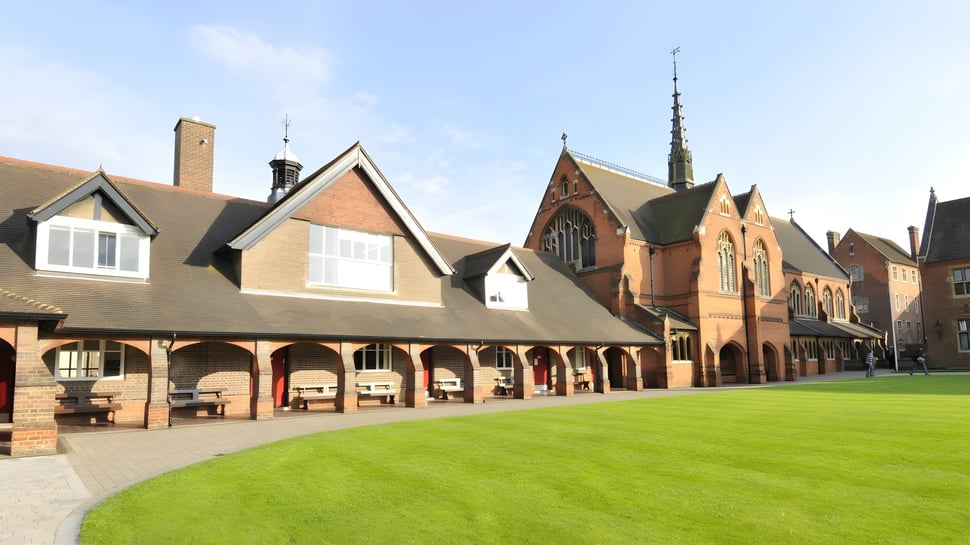 Der Innenhof der Berkhamsted School zeigt einen grasbewachsenen Hof umgeben von historischem Backsteingebäude mit Bögen.