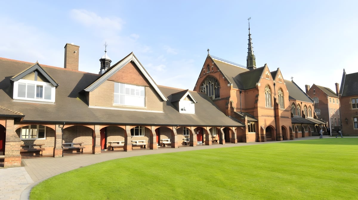 Der Innenhof der Berkhamsted School zeigt einen grasbewachsenen Hof umgeben von historischem Backsteingebäude mit Bögen.