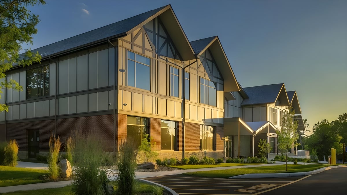 Das moderne Gebäude der Bethany School mit Holz- und Glasfassade umgeben von Grünflächen und einem Gehweg zum Eingang.