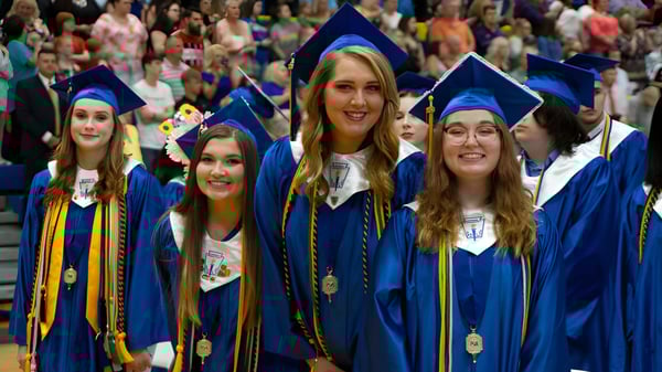 Absolventen der Bethlehem High School stehen in blauen und goldenen Abschlussgewändern gemeinsam in einer vollen Aula.