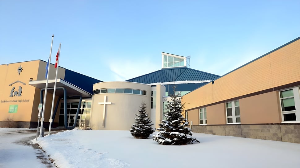 Der verschneite Innenhof mit dem modernen mehrstöckigen Gebäude der Bethlehem High School unter blauem Himmel.