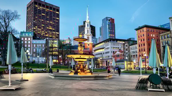 Menschen spazieren über den belebten Platz vor der Skyline der Stadt in der Nähe der Beverly High School.