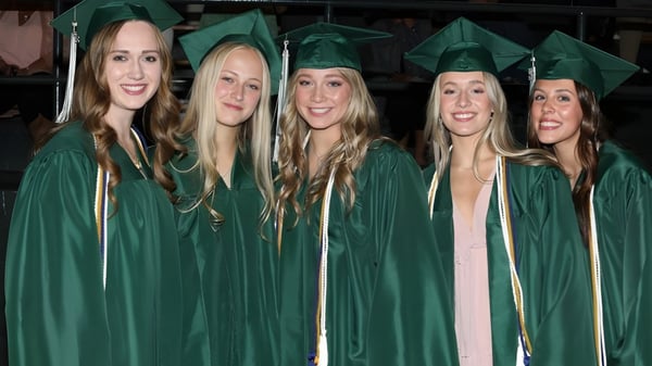 Fünf Schülerinnen der Billings Central Catholic High School feiern gemeinsam ihren Abschluss in grünen Talaren.