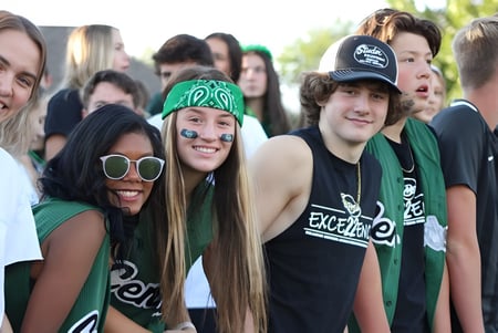 Eine Gruppe von Schülerinnen und Schülern der Billings Central Catholic High School versammelt sich draußen und lächelt gemeinsam.