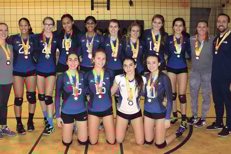 Eine Gruppe junger Volleyballspielerinnen des Birchmount Park Collegiate Institute steht mit Medaillen und Pokalen in einer Turnhalle.