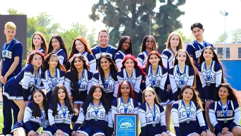 Eine Gruppe von Schülerinnen und Schülern des Birmingham Community Charter High School posiert als Sportteam vor einem Gebäude im Freien.