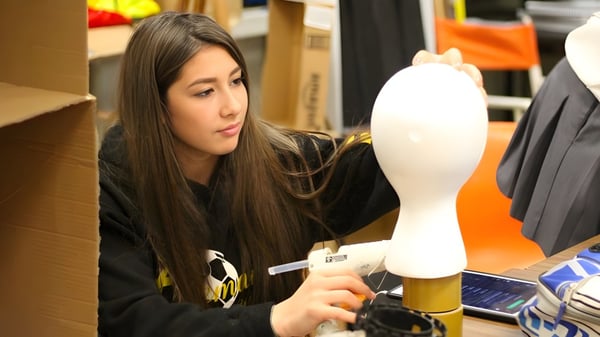 Eine Schülerin der Bishop Alemany High School arbeitet konzentriert in der Werkstatt an einer praktischen Aufgabe.