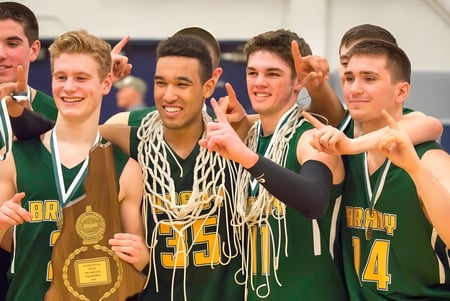 Eine Gruppe männlicher Basketballschüler der Bishop Brady High School feiert mit einem Pokal nach dem Spiel.