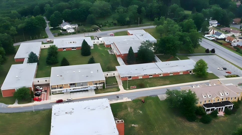 Der weitläufige Campus der Bishop Carroll High School ist von grüner Landschaft und einer geschwungenen Straße umgeben.