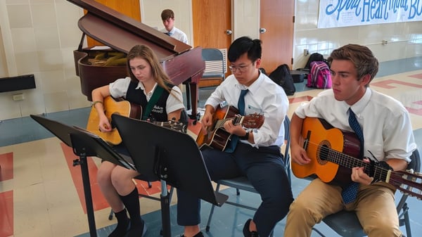 Eine Gruppe Schüler spielt Gitarren und tritt mit weiteren Instrumenten auf dem Campus der Bishop Carroll High School auf.