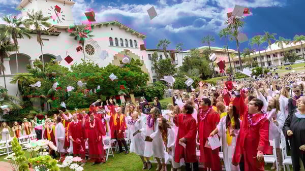 Absolventinnen und Absolventen der Bishop Garcia Diego High School versammeln sich vor einem Gebäude mit Palmen unter blauem Himmel.
