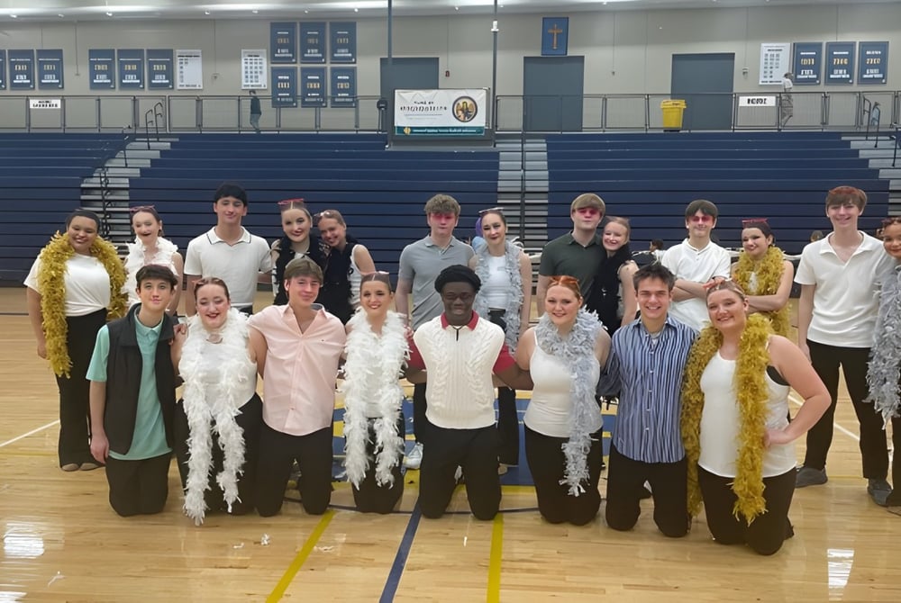 Eine Gruppe Schüler der Bishop Heelan Catholic High School steht gemeinsam in der Sporthalle.