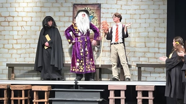 Schüler der Bishop Heelan Catholic High School führen eine Theateraufführung mit aufwendigen Kostümen auf der Bühne auf.