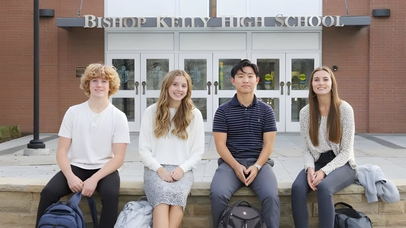 Vier Schüler sitzen auf einer Bank vor dem Gebäude der Bishop Kelly High School.