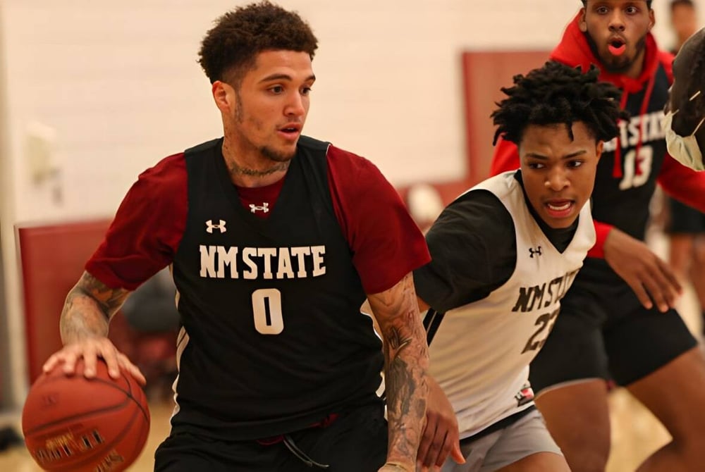 Zwei Basketballspieler in der Uniform dribbeln und kämpfen auf dem Spielfeld der Bishop McNally High School.