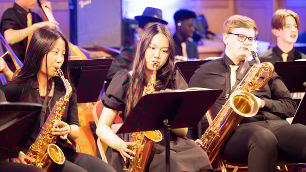 Eine Gruppe Musiker, darunter Saxophonisten, tritt auf der Bühne des Bishop’s Stortford College auf.
